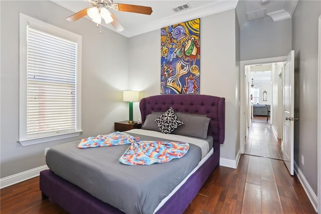 bedroom with dark hardwood / wood-style flooring, ceiling fan, and multiple windows