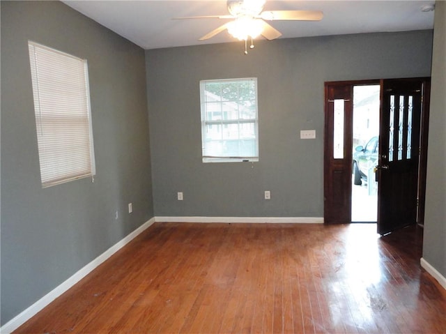 foyer entrance with ceiling fan and dark wood-type flooring