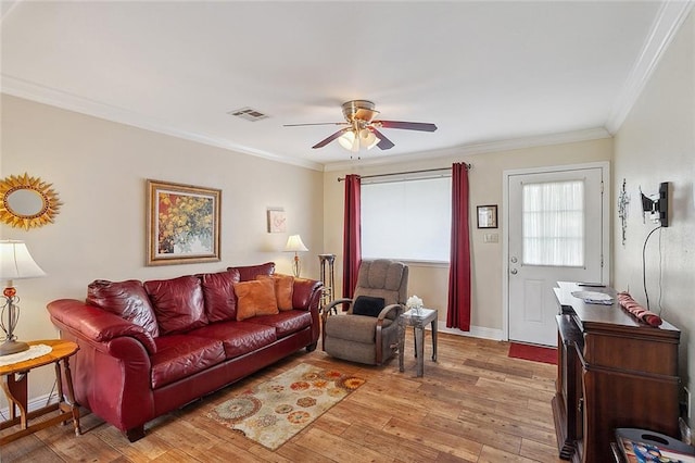 living room with ornamental molding, light hardwood / wood-style floors, and ceiling fan