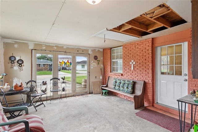 living area with concrete floors and brick wall