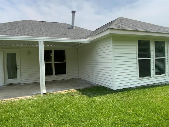 rear view of house with a lawn and a patio area