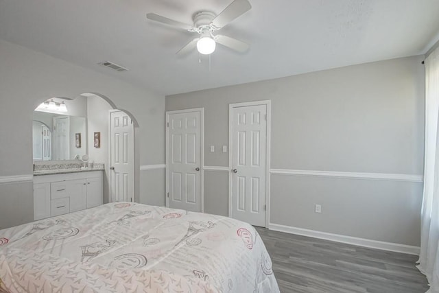 bedroom featuring connected bathroom, ceiling fan, and dark hardwood / wood-style floors