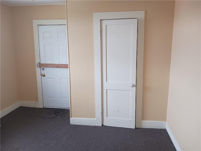 unfurnished bedroom featuring dark carpet