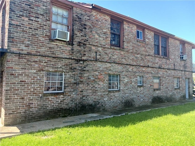 view of side of home featuring cooling unit and a lawn