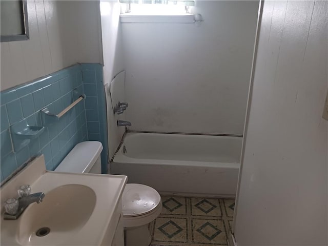 full bathroom featuring sink, washtub / shower combination, tile walls, and toilet