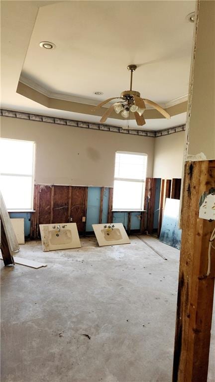 miscellaneous room featuring ceiling fan, crown molding, and a tray ceiling