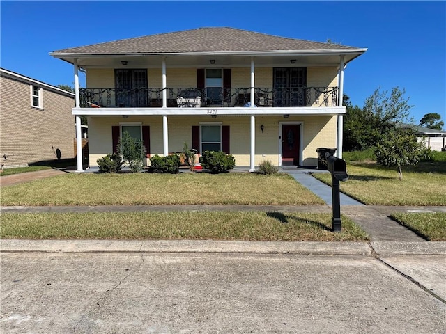 view of front of property featuring a front lawn and a balcony