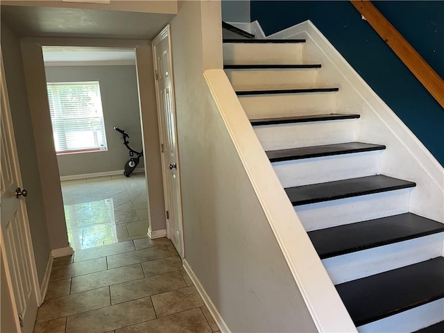 staircase featuring ornamental molding and tile floors