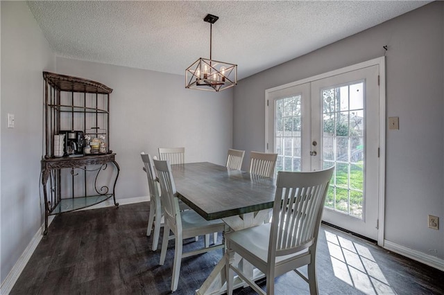 dining room featuring a healthy amount of sunlight, dark hardwood / wood-style floors, a chandelier, and french doors