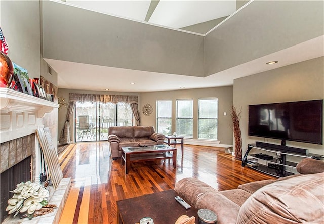 living room with a towering ceiling and wood-type flooring