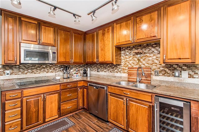 kitchen with appliances with stainless steel finishes, tasteful backsplash, wine cooler, sink, and rail lighting