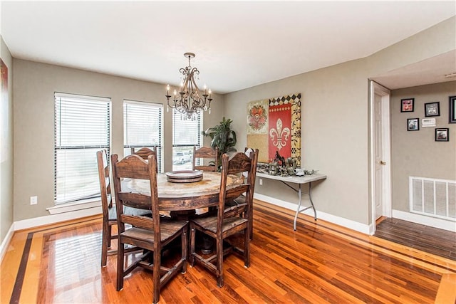 dining area featuring a notable chandelier and hardwood / wood-style floors