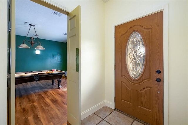 foyer with a chandelier, light hardwood / wood-style floors, and pool table