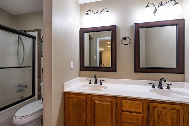 full bathroom featuring enclosed tub / shower combo, toilet, and double vanity