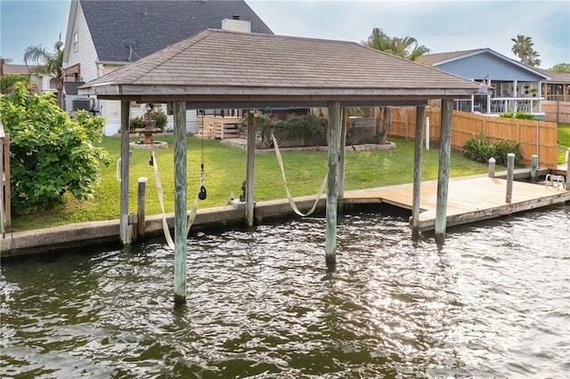 dock area with a gazebo, a water view, and a yard