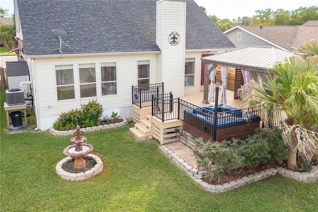 back of property featuring a deck, a lawn, and central AC