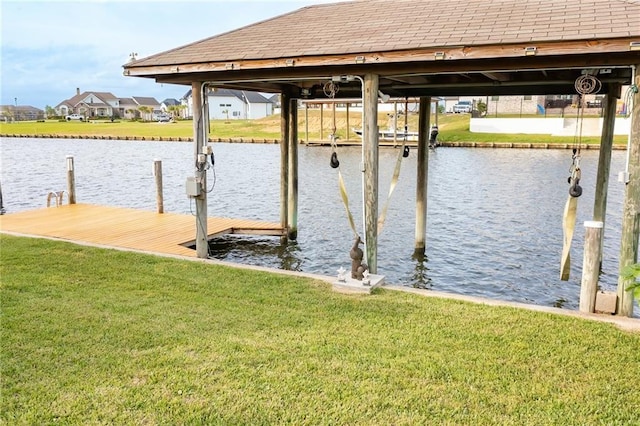 dock area featuring a water view and a lawn