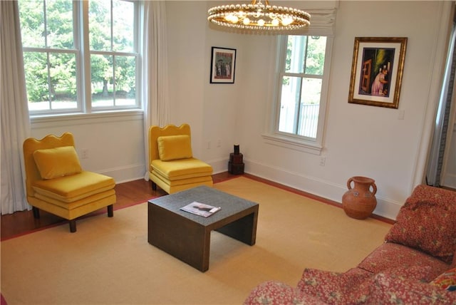 living room with an inviting chandelier, hardwood / wood-style flooring, and a wealth of natural light