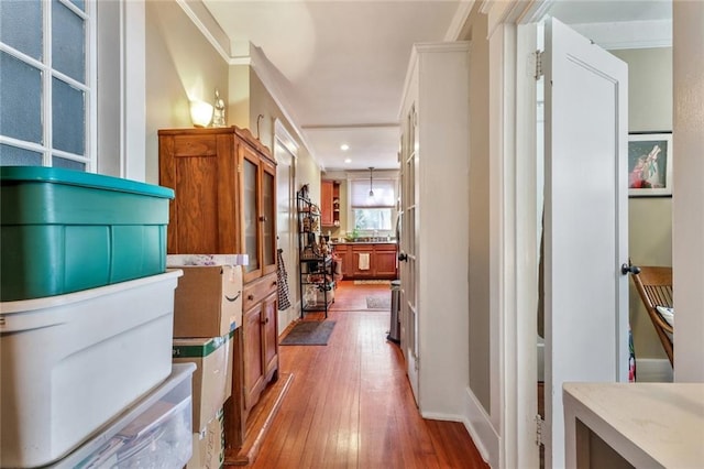 hallway with hardwood / wood-style flooring and ornamental molding