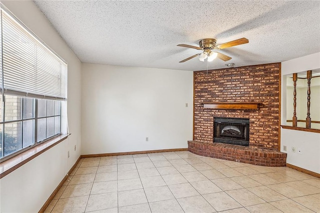 unfurnished living room featuring light tile floors, plenty of natural light, ceiling fan, and a brick fireplace