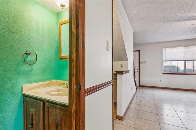 bathroom featuring tile flooring, oversized vanity, and a textured ceiling