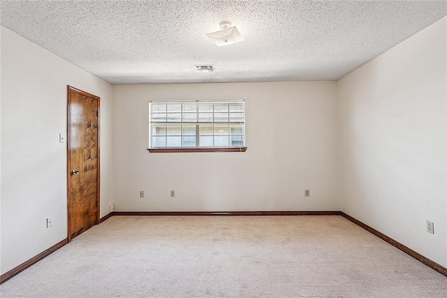 carpeted empty room featuring a textured ceiling