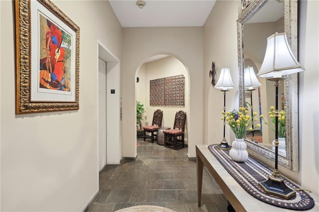 hall featuring dark tile flooring