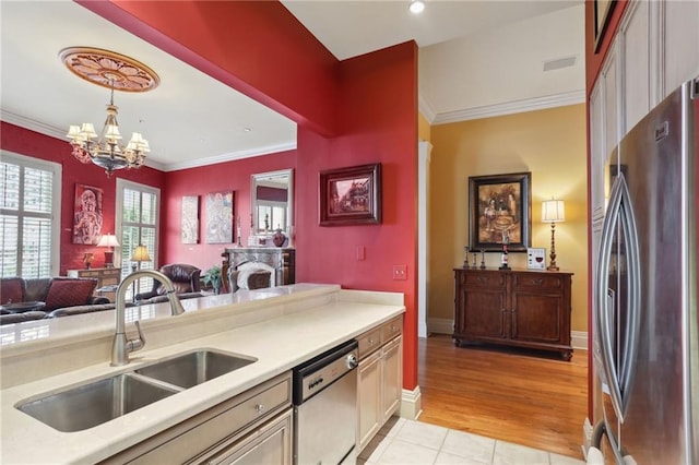 kitchen featuring light hardwood / wood-style floors, stainless steel appliances, sink, hanging light fixtures, and an inviting chandelier