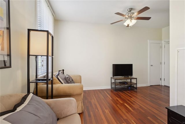 living room with dark wood-type flooring, ceiling fan, and a healthy amount of sunlight