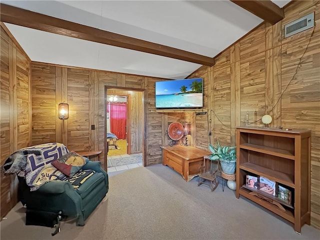 sitting room featuring light carpet, beam ceiling, and wooden walls