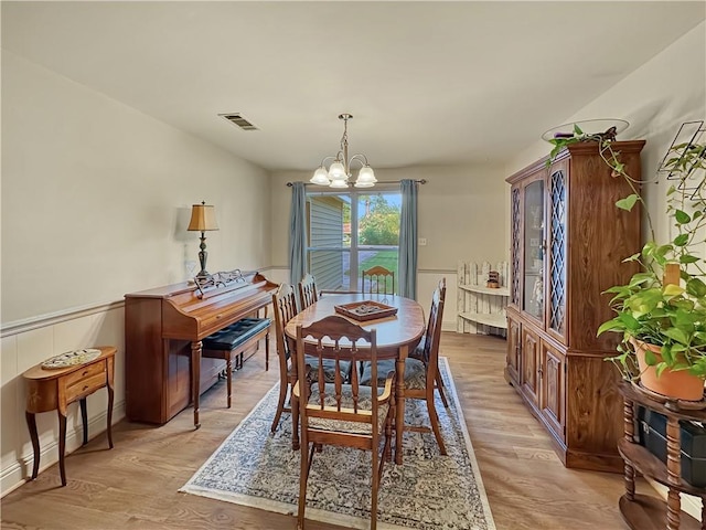 dining area featuring light hardwood / wood-style flooring and a chandelier