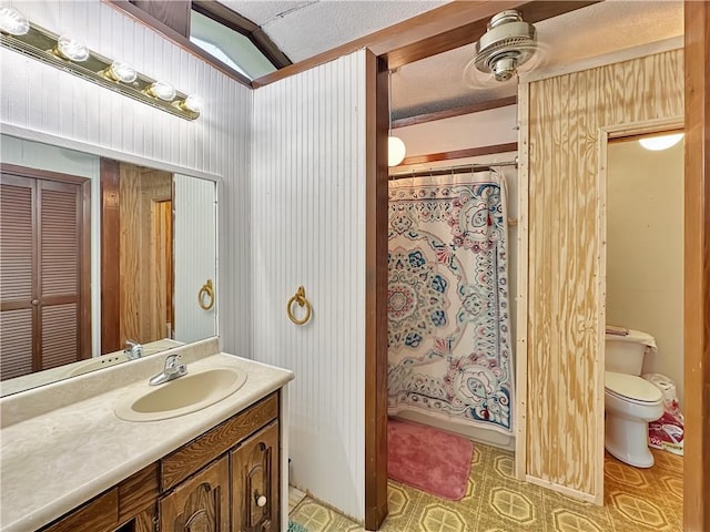 bathroom with tile floors, toilet, a textured ceiling, and vanity