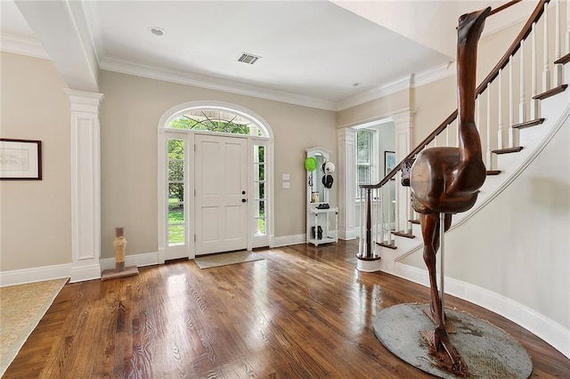 entryway with crown molding, decorative columns, and dark wood-type flooring