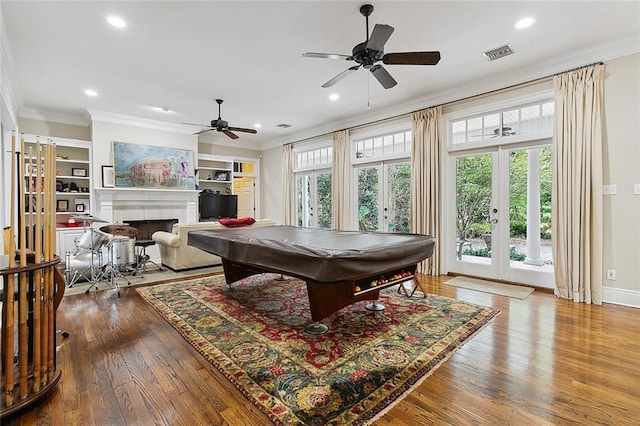 game room with ceiling fan, french doors, ornamental molding, built in features, and light wood-type flooring