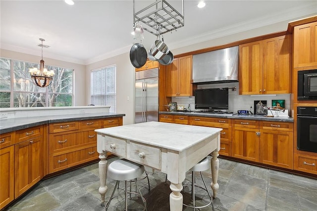 kitchen with a chandelier, wall chimney range hood, black appliances, backsplash, and dark tile floors