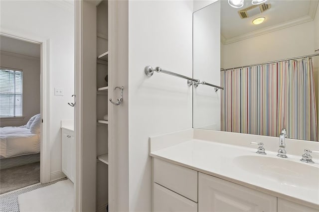 bathroom with crown molding and vanity with extensive cabinet space