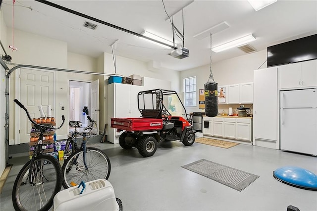 garage with a garage door opener and white refrigerator