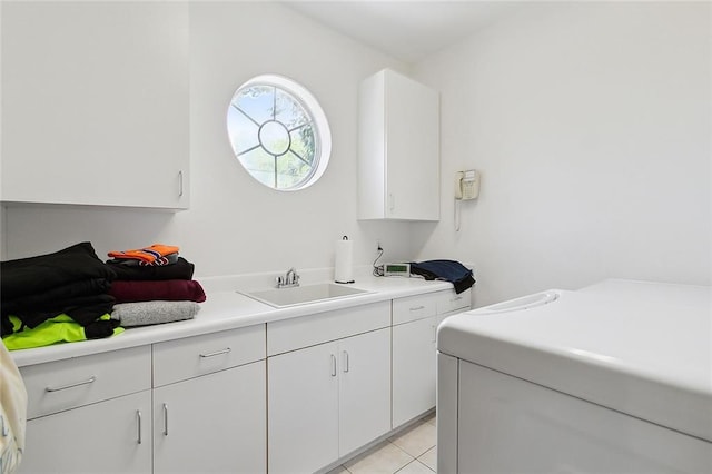 clothes washing area featuring cabinets, sink, and light tile floors