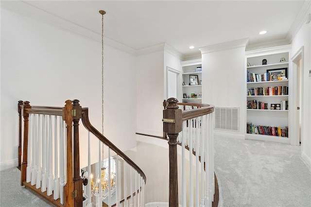 interior space with built in features, ornamental molding, and light carpet