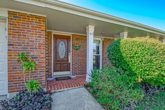 entrance to property featuring brick siding and an attached garage