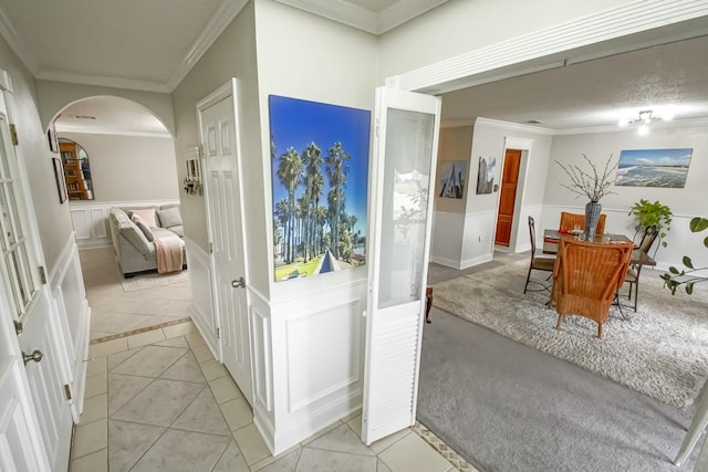 hall with light tile flooring and ornamental molding