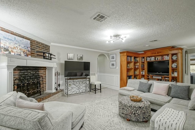 living room featuring a brick fireplace, a textured ceiling, ornamental molding, and light tile floors