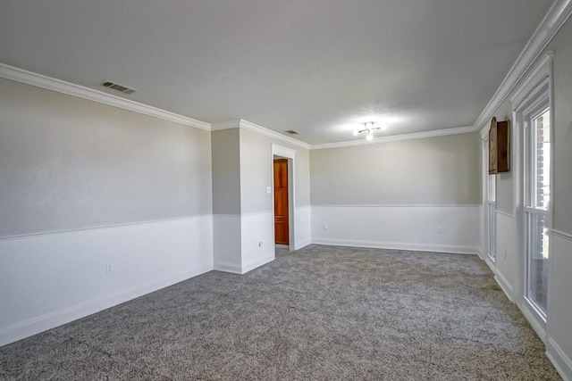 empty room with carpet floors, visible vents, and crown molding