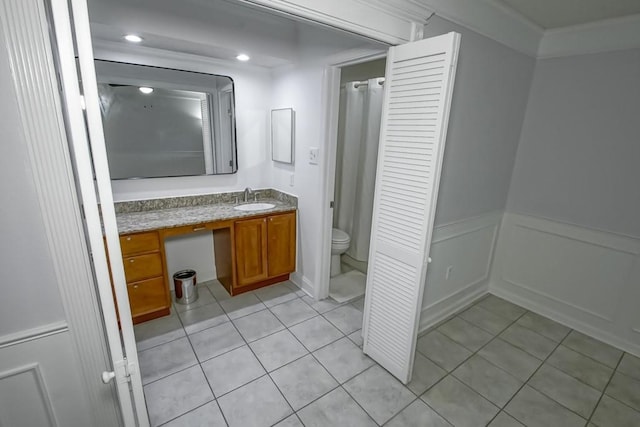 full bath with wainscoting, vanity, toilet, and tile patterned floors