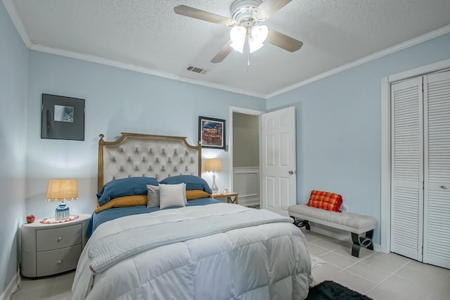 bedroom with visible vents, ornamental molding, tile patterned floors, a textured ceiling, and a closet