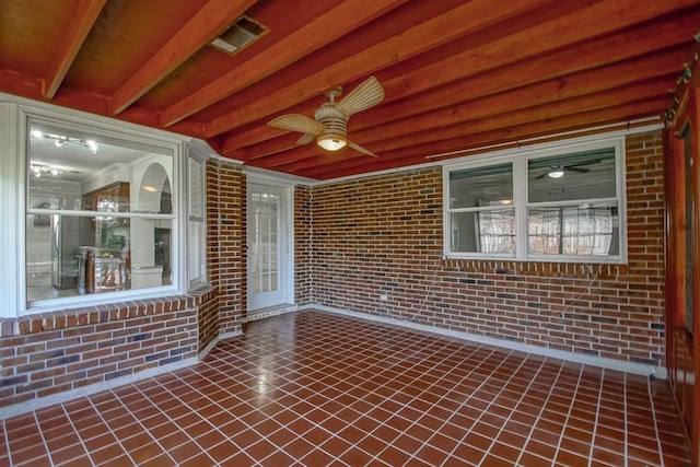 unfurnished sunroom with visible vents and a ceiling fan