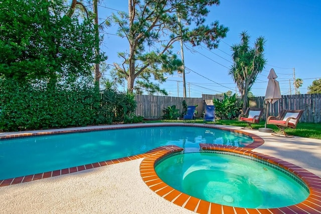 view of swimming pool with a patio area, a pool with connected hot tub, and a fenced backyard