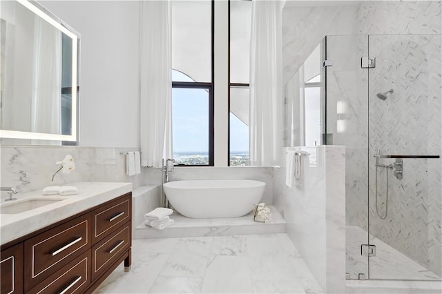 bathroom with vanity, shower with separate bathtub, and tile walls