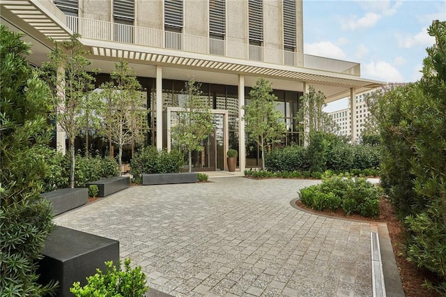 view of exterior entry featuring a balcony and a patio area