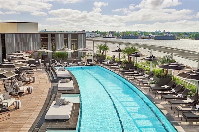 view of pool featuring a water view and a patio area